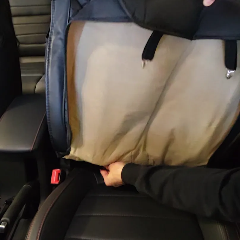 Plastic discs being slid into the gap between the backrest and the seat cushion